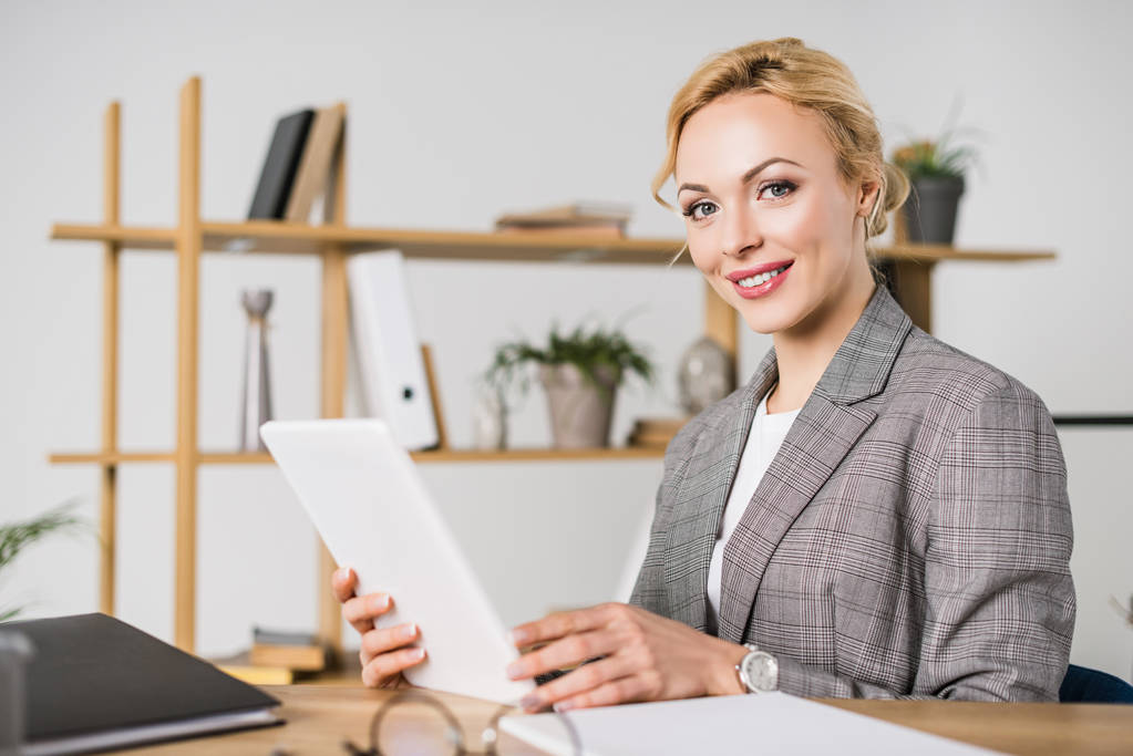 retrato de mulher de negócios atraente com tablet sentado no local de trabalho
 - Foto, Imagem