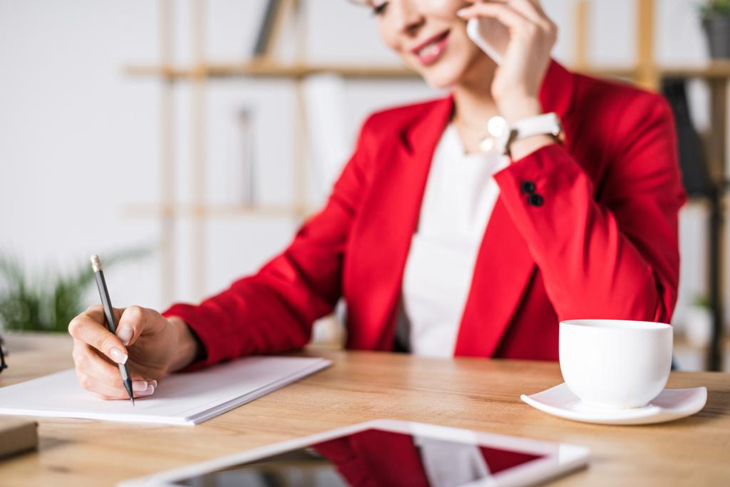 επιλεκτική εστίαση του επιχειρηματίας μιλάει στο smartphone στο χώρο εργασίας στο γραφείο - Φωτογραφία, εικόνα