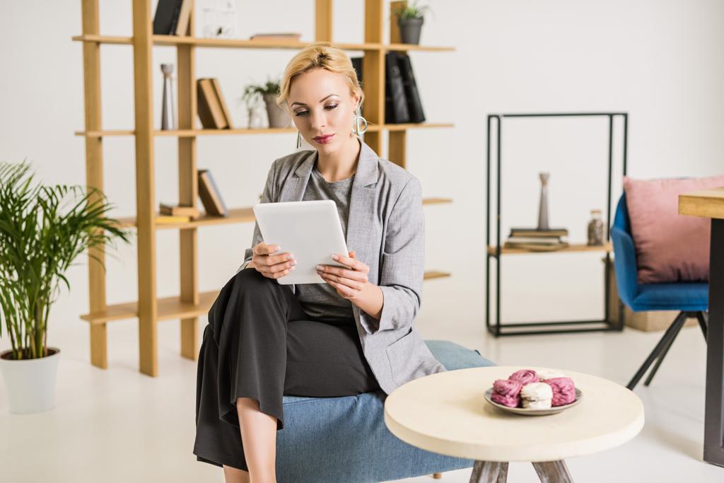 hermosa mujer de negocios utilizando tableta descansando en la silla en la oficina
 - Foto, Imagen
