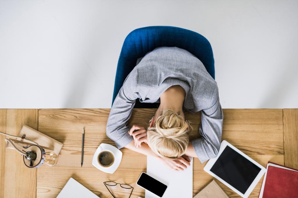 над головой вид уставшей деловой женщины, спящей на рабочем месте в офисе
 - Фото, изображение