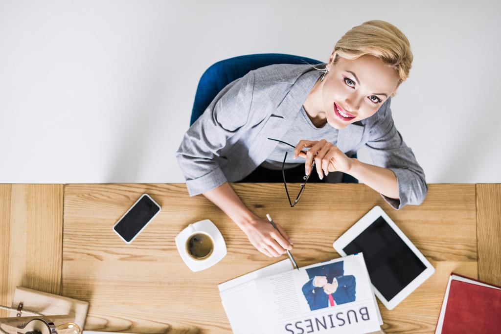 overhead view of smiling businesswoman at workplace in office - Photo, Image