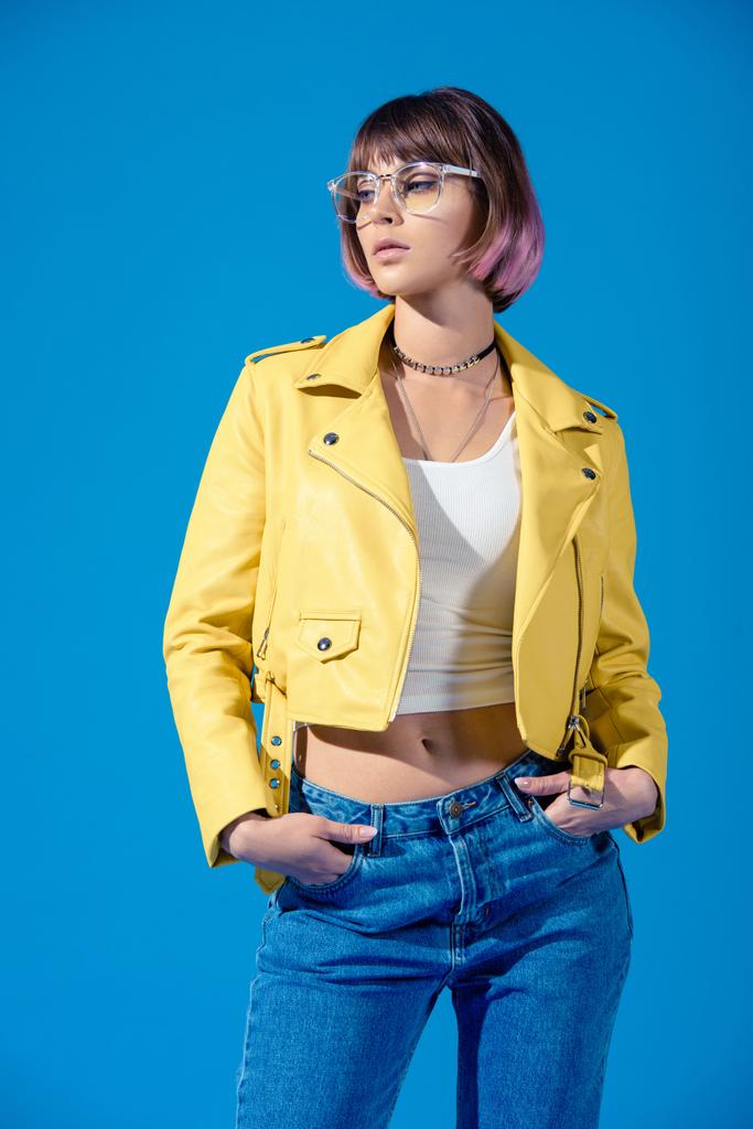 стильная девушка позирует в джинсах и кожаной куртке изолированы на синий
 - Фото, изображение