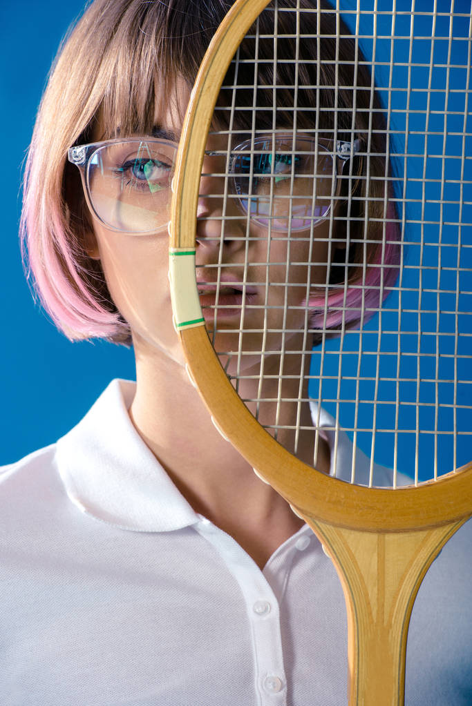 portrait de joueur de tennis couvrant la moitié du visage avec raquette de tennis isolée sur bleu
 - Photo, image