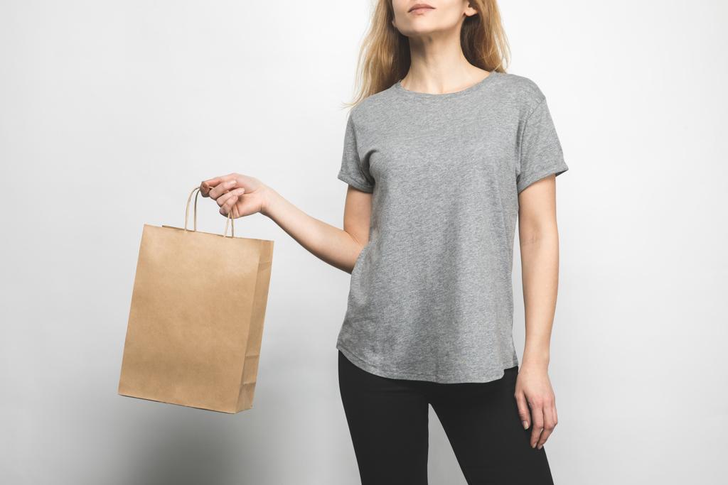 περικοπεί shot γυναίκας στο κενό t-shirt γκρι για τη λευκή με τσάντα για ψώνια - Φωτογραφία, εικόνα
