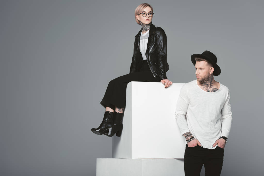élégant jeune couple tatoué posant ensemble isolé sur gris
 - Photo, image