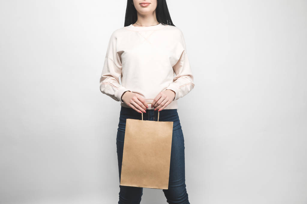 Młoda kobieta w puste Bluza na białym z torbą na zakupy - Zdjęcie, obraz