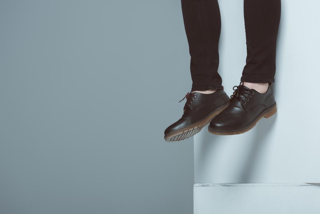 cropped view of man in trendy shoes on white cubes, isolated on grey - Photo, Image