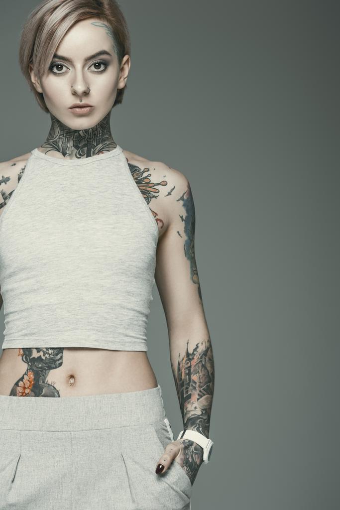 kaunis tatuoitu tyttö, eristetty harmaalla
 - Valokuva, kuva