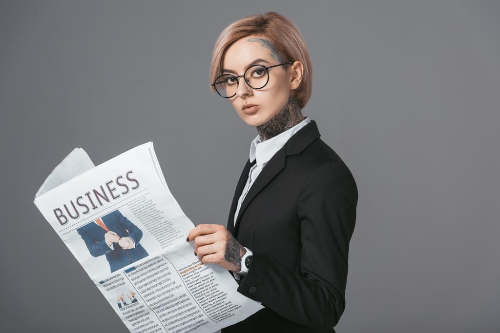 kobieta interesu w okularach i garnitur czytanie gazety biznesowej, na szarym tle - Zdjęcie, obraz