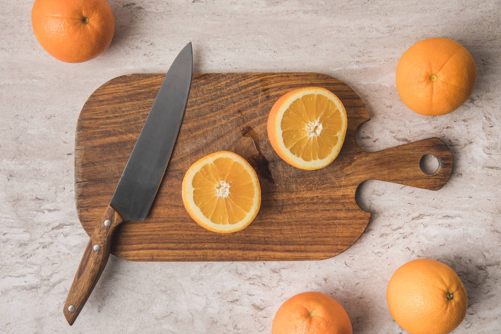 vista superior de corte naranja y cuchillo sobre tabla de madera
  - Foto, imagen