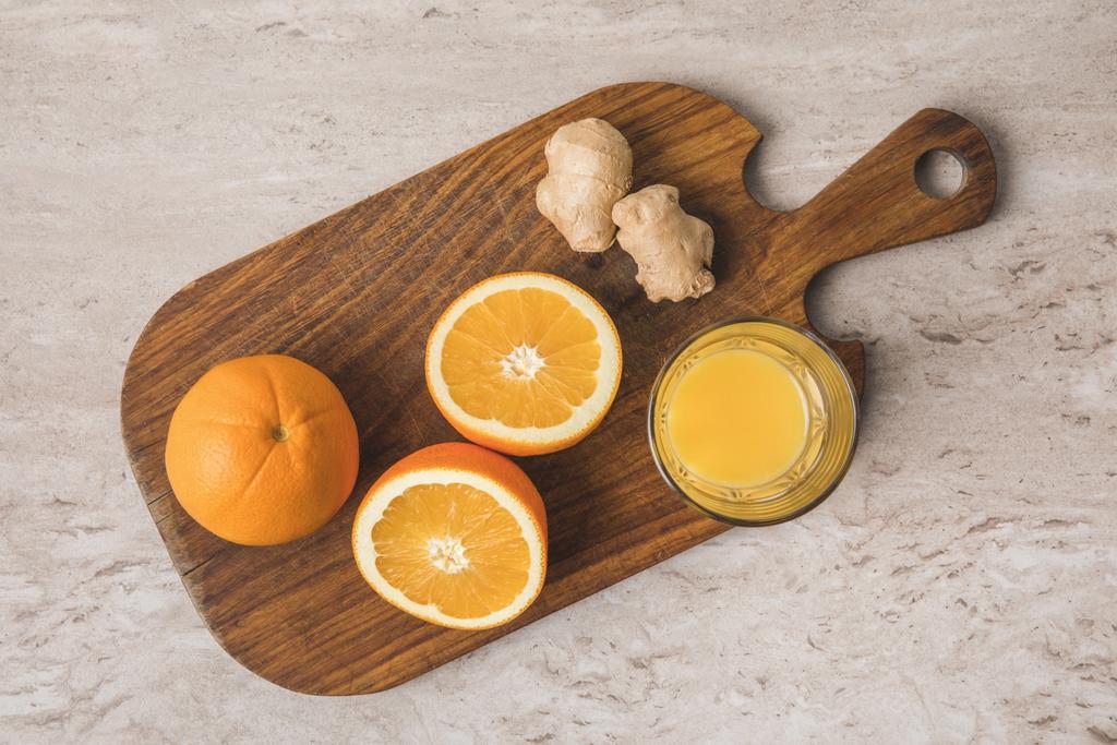 vue de dessus des oranges, du gingembre et du jus sur planche à découper
 - Photo, image