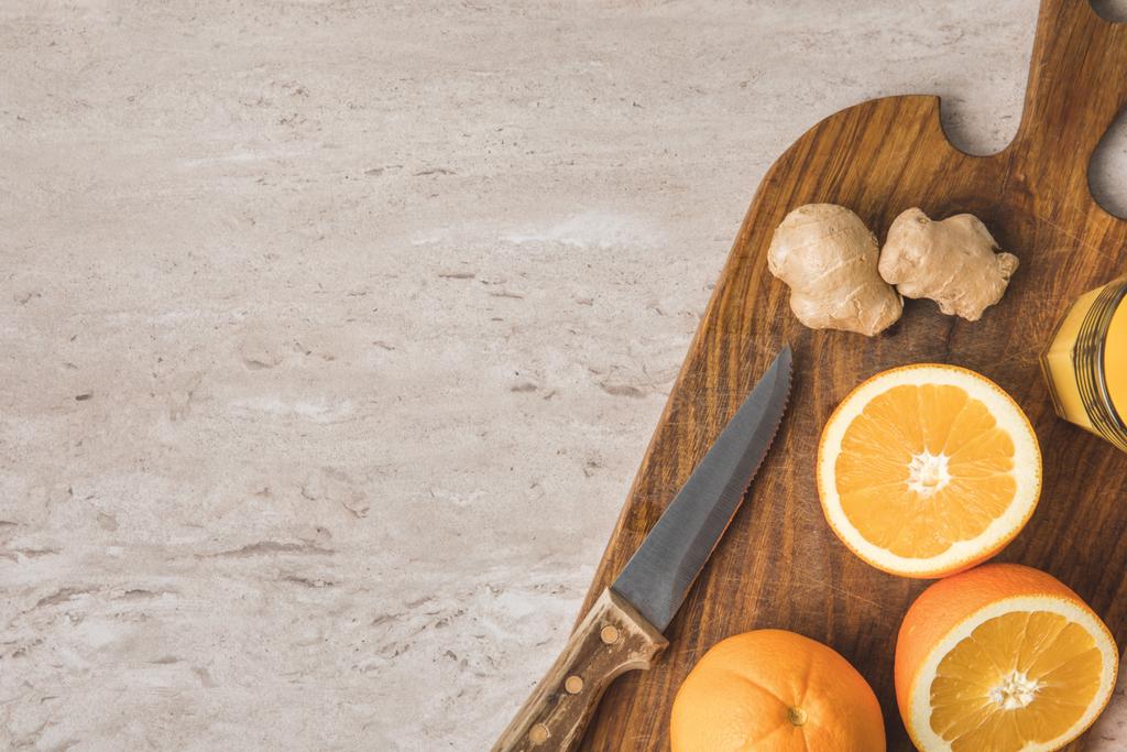 вид апельсинов, ножа и имбиря на мраморную поверхность
 - Фото, изображение