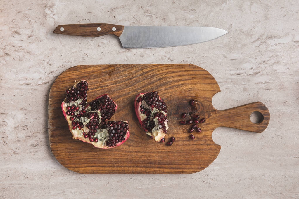 top view of ripe pomegranate on cutting board  - Photo, Image