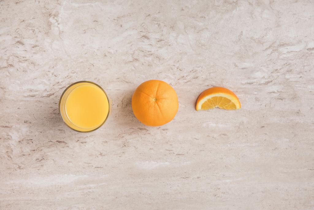 το Top view ποτήρι φρέσκο χυμό πορτοκαλιού και τα πορτοκάλια στον πίνακα - Φωτογραφία, εικόνα