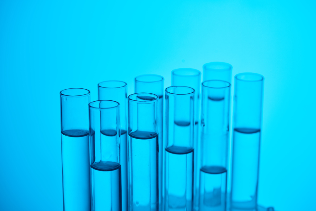 glazen buizen met vloeistof voor chemische test op blauw - Foto, afbeelding