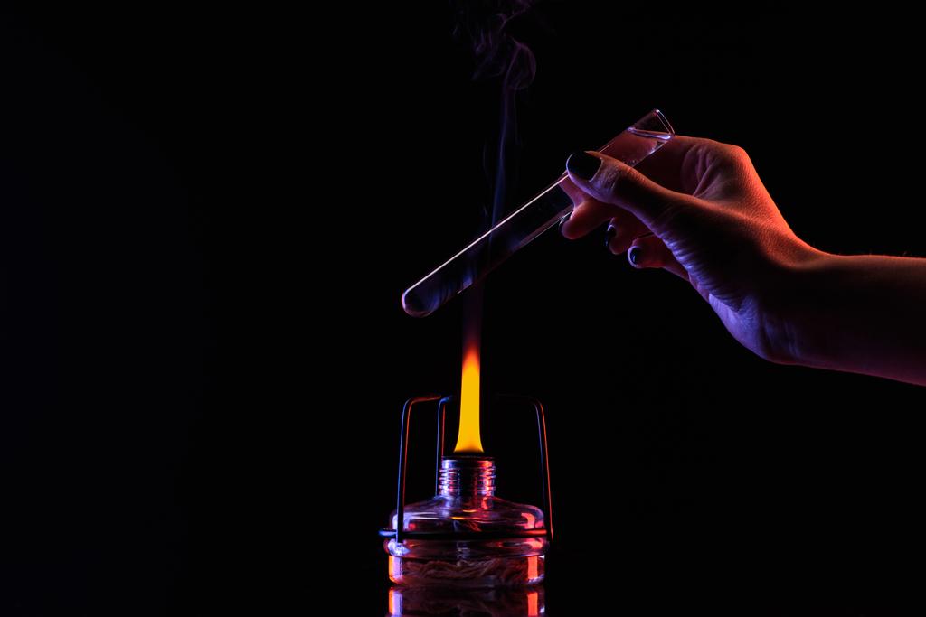 imagen recortada de químico calentando tubo con líquido en negro
  - Foto, Imagen