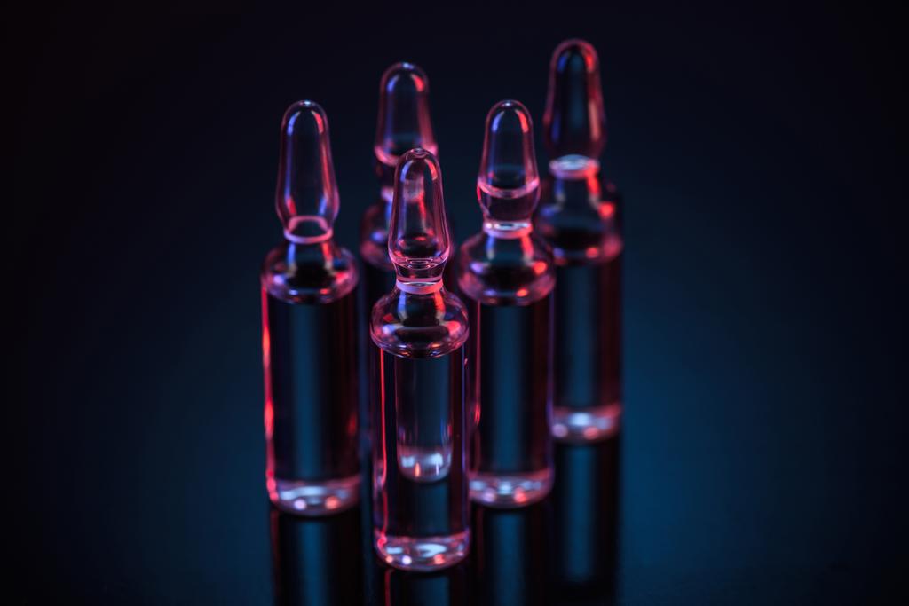 cinco ampollas de vidrio transparente con sustancia sobre la mesa
 - Foto, Imagen