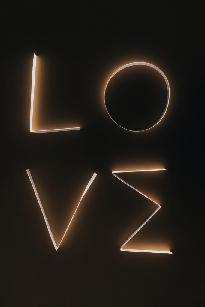 word LOVE made of paper stripes on dark surface - Photo, Image