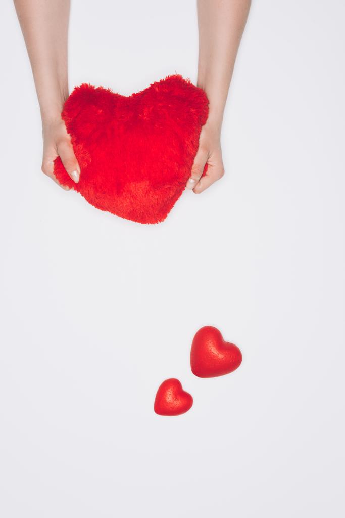 rajattu laukaus nainen puristamalla pehmeä punainen sydän tyyny eristetty valkoinen
 - Valokuva, kuva