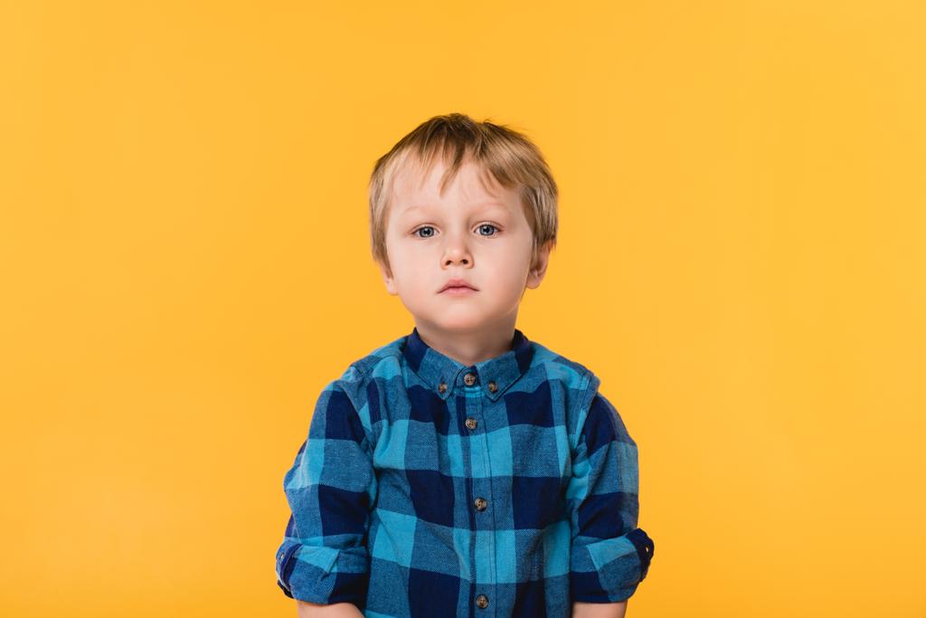 πορτρέτο του μικρού αγοριού στο πουκάμισο που βλέπουν τα φωτογραφικών μηχανών που απομονώνονται σε κίτρινο - Φωτογραφία, εικόνα