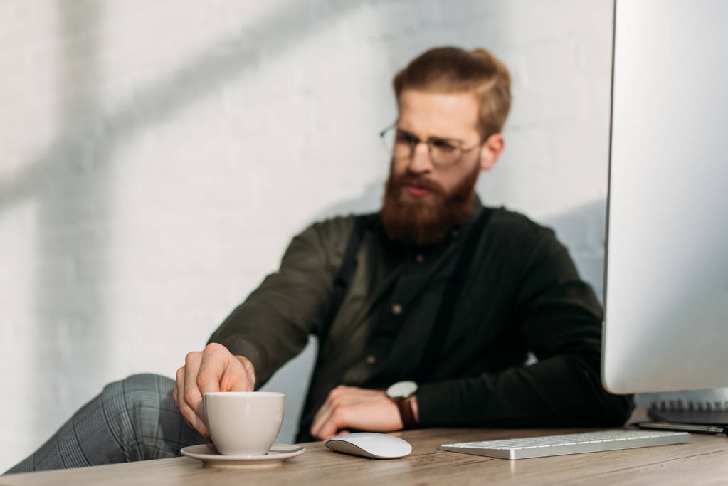 zakenman nemen kopje koffie uit werktafel - Foto, afbeelding