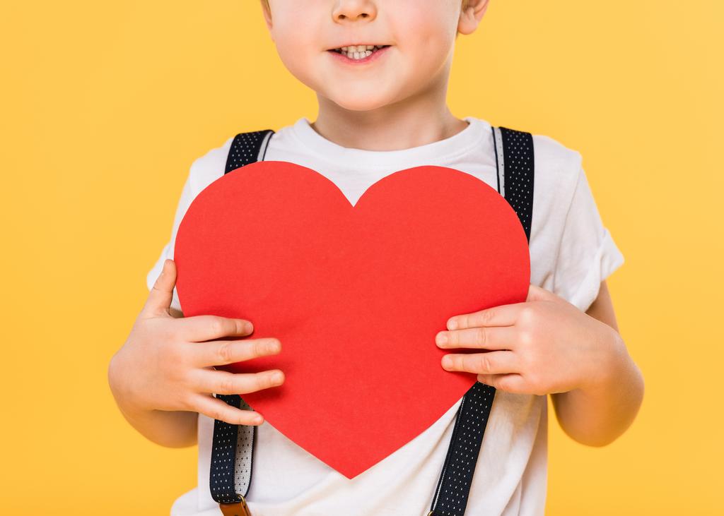 частковий вид на дитину з червоним паперовим серцем ізольовано на жовтому, концепція дня святого Валентина
 - Фото, зображення