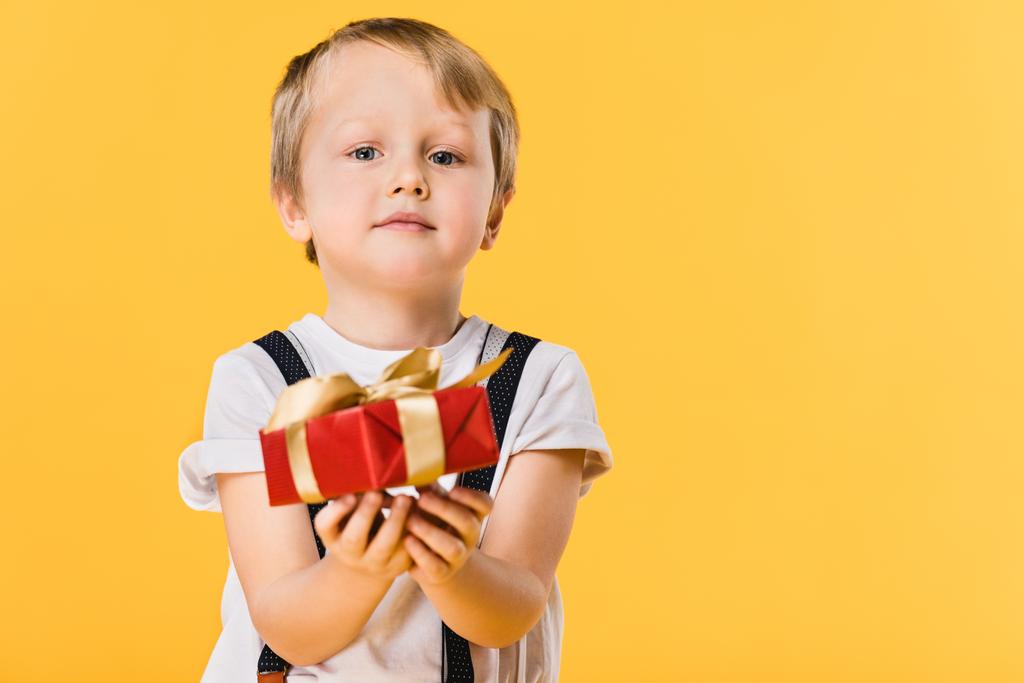 selective focus of little boy with wrapped present isolated on yellow - Photo, Image