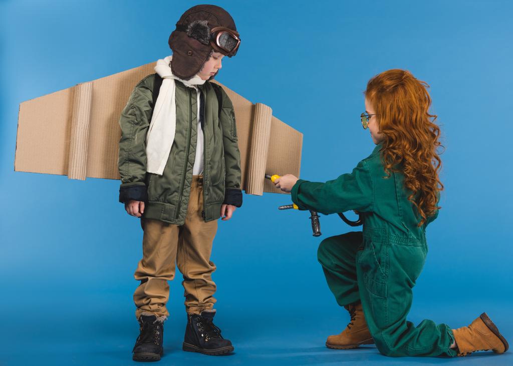 kids in pilot costumes with toy screwdriver playing together isolated on blue - Photo, Image