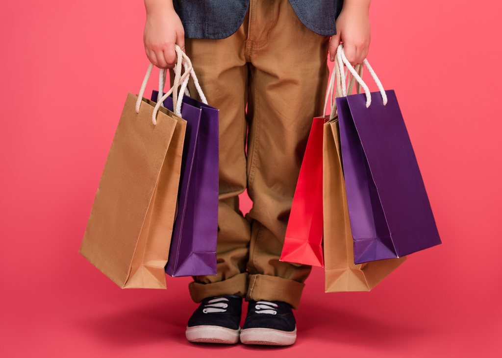 vista parcial de los niños y bolsas de compras aisladas en rosa
 - Foto, imagen