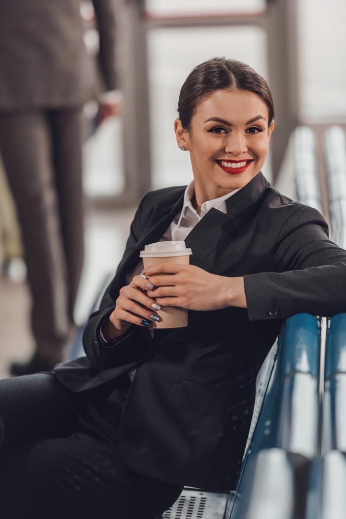 joven mujer de negocios esperando avión en el aeropuerto y tomando una taza de café para ir
 - Foto, Imagen