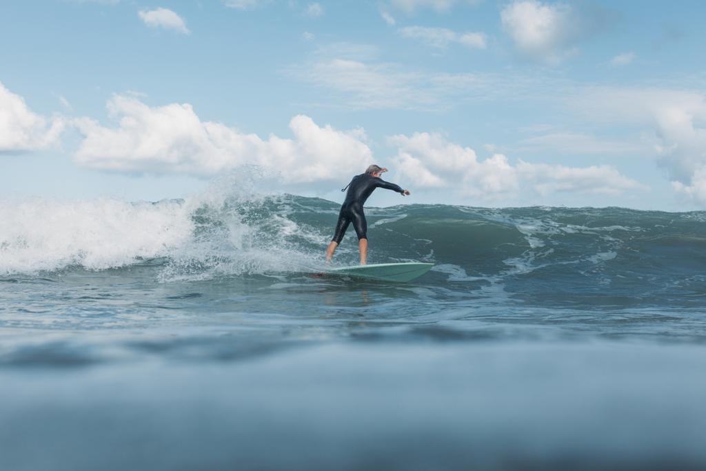 male surfer riding wave on surf board in ocean  - Photo, Image