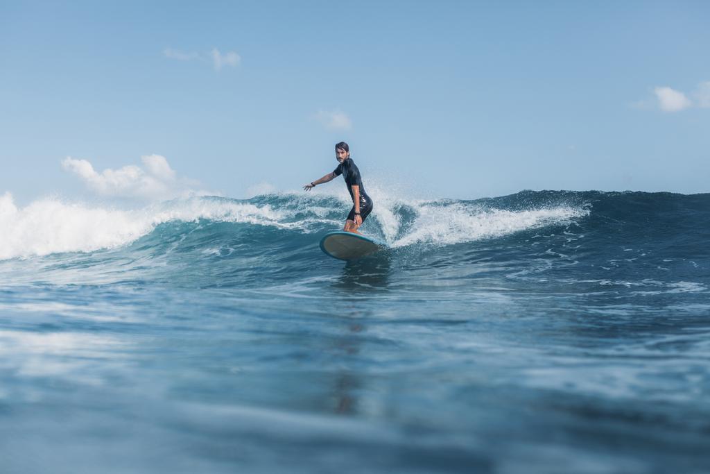 Sportman surfen wave op surfplank in Oceaan  - Foto, afbeelding