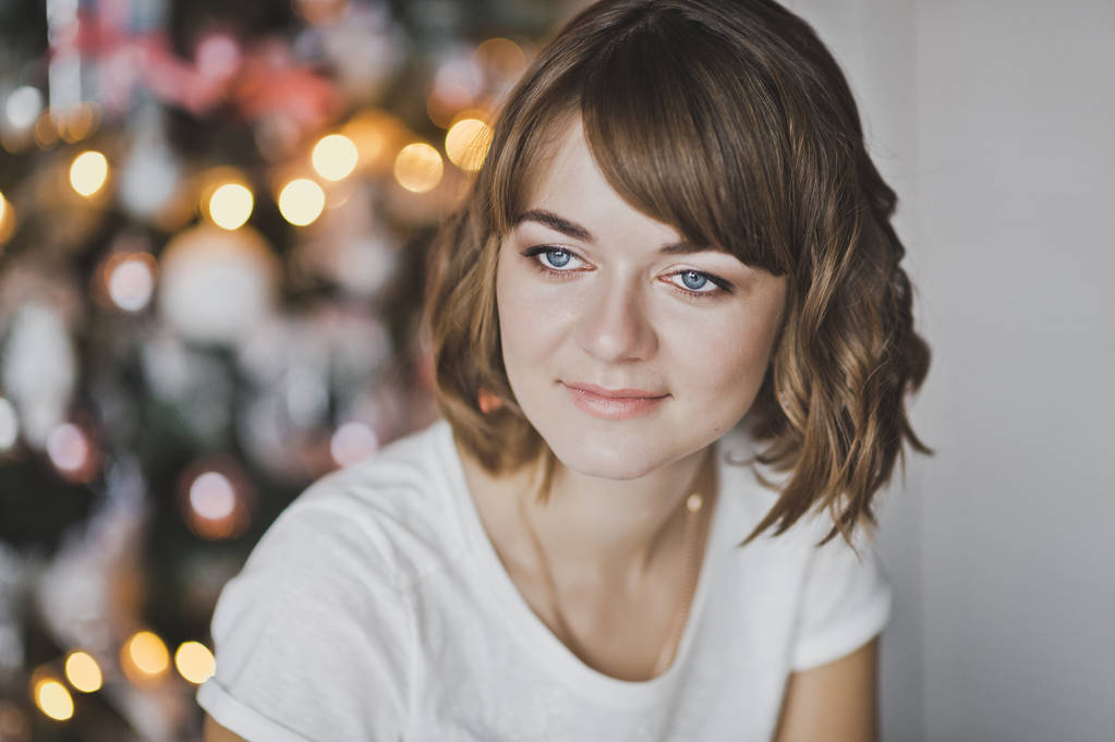 Retrato de una hermosa chica en una camiseta blanca en la Navidad
 - Foto, imagen