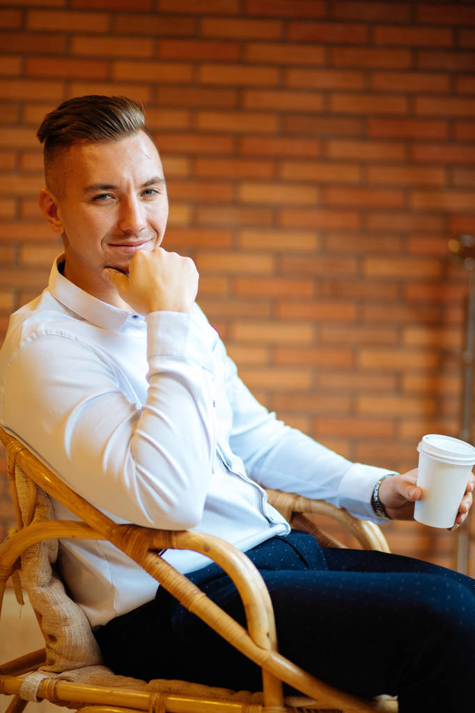 красивый бизнесмен пьет кофе дома и смотрит в камеру
 - Фото, изображение