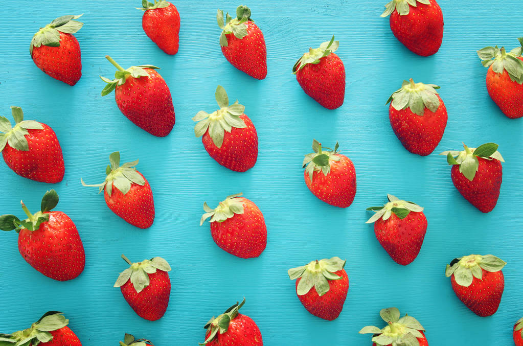 Draufsicht Hintergrund von frischen Erdbeeren über blauem Holztisch. - Foto, Bild