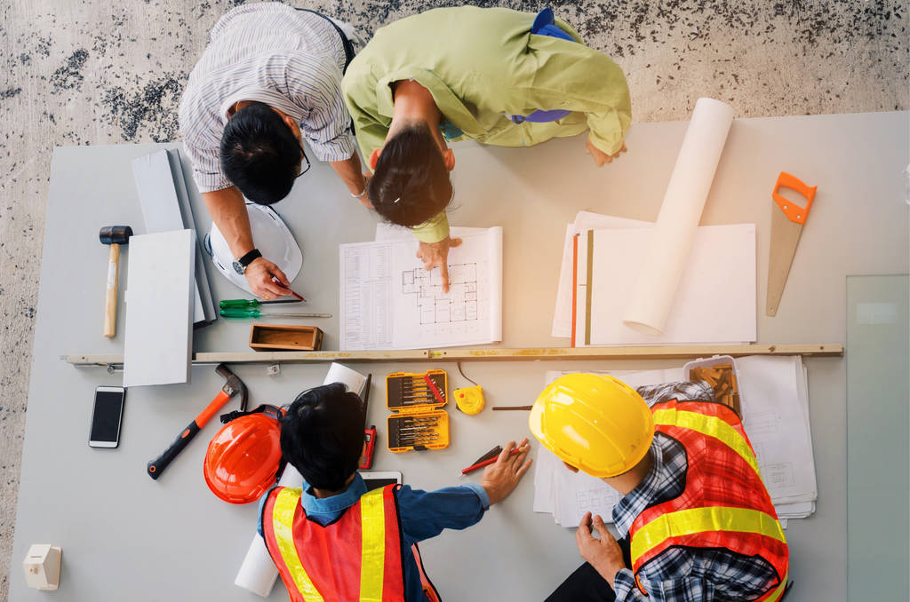 top view of group of engineer, technician and architect planning about building plan with blueprint and construction tools on the conference table at construction site, business and industry concept - Photo, Image