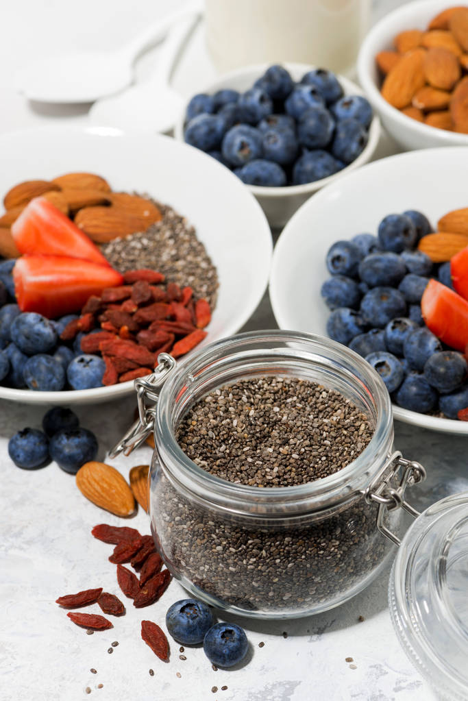 semillas de chía en un frasco, bayas y frutos secos para un desayuno saludable
  - Foto, imagen