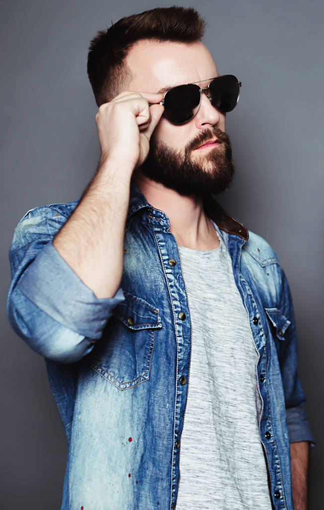 Стильный, современный бородатый мужчина в черных очках и джинсовой рубашке
. - Фото, изображение