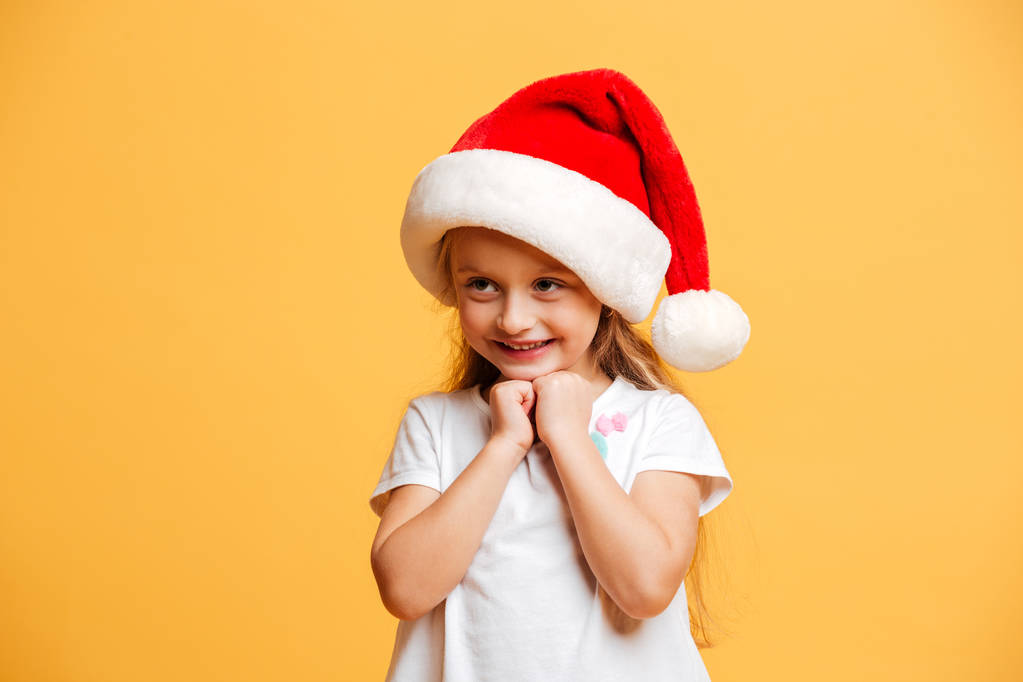 Neşeli kız ayakta izole giyen Noel Noel Baba şapkası - Fotoğraf, Görsel