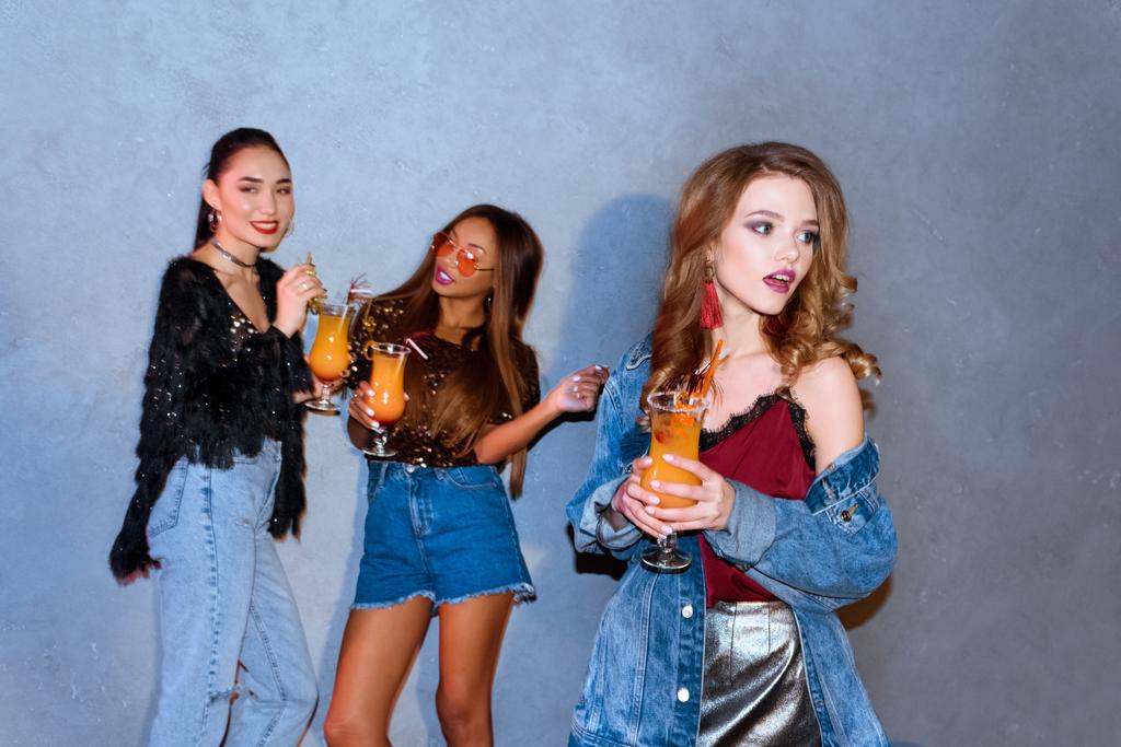 stylish young multi ethnic women holding glasses with cocktails at party - Photo, Image