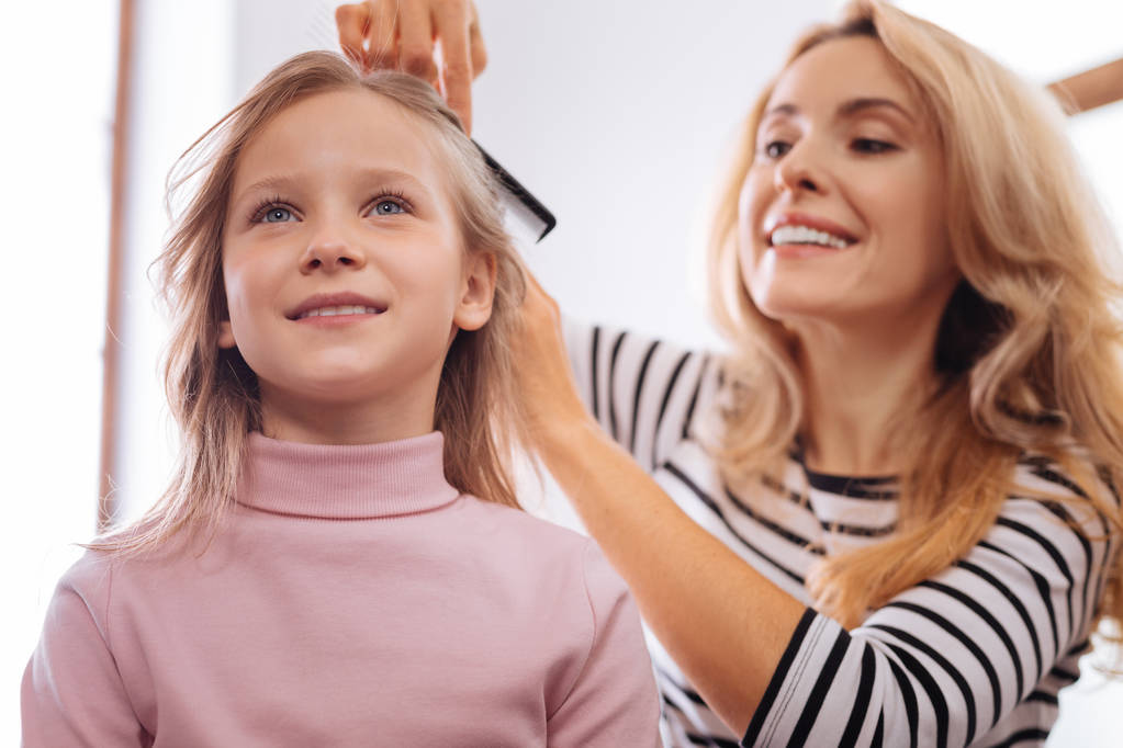 Loving mother combing her daughters hair - Photo, Image