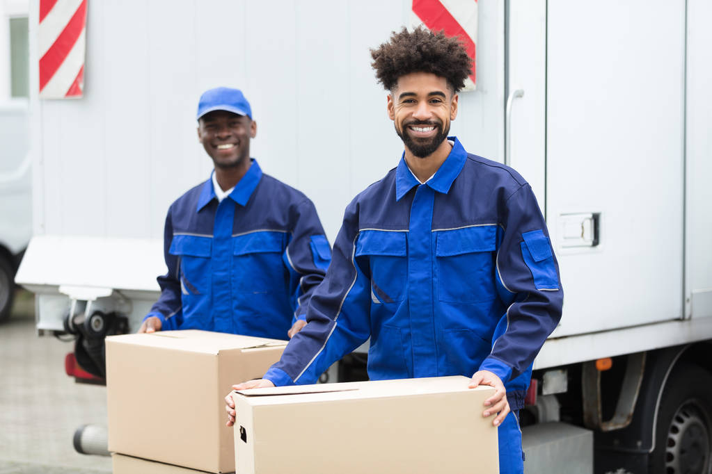 Close-up Of Two Delivery Men Holding The Cardboard Boxes - Photo, Image