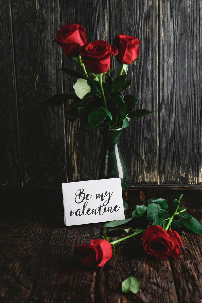 Red roses in vase and Be my valentine card on shabby wooden background - Photo, Image