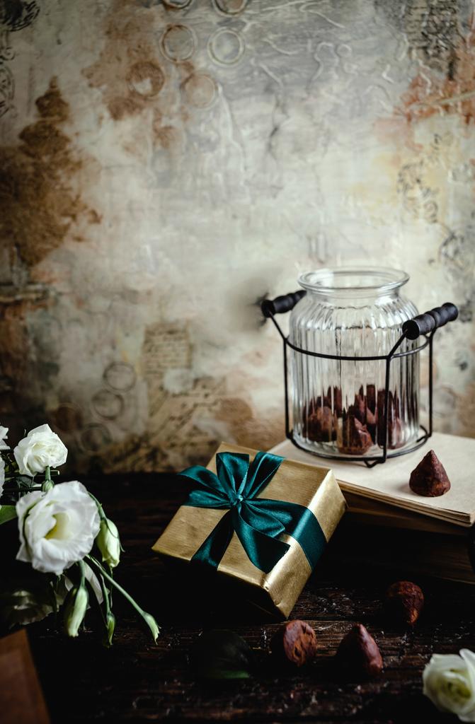 bloemen, doos van de gift en glazen pot met chocolade snoepjes voor valentines day - Foto, afbeelding