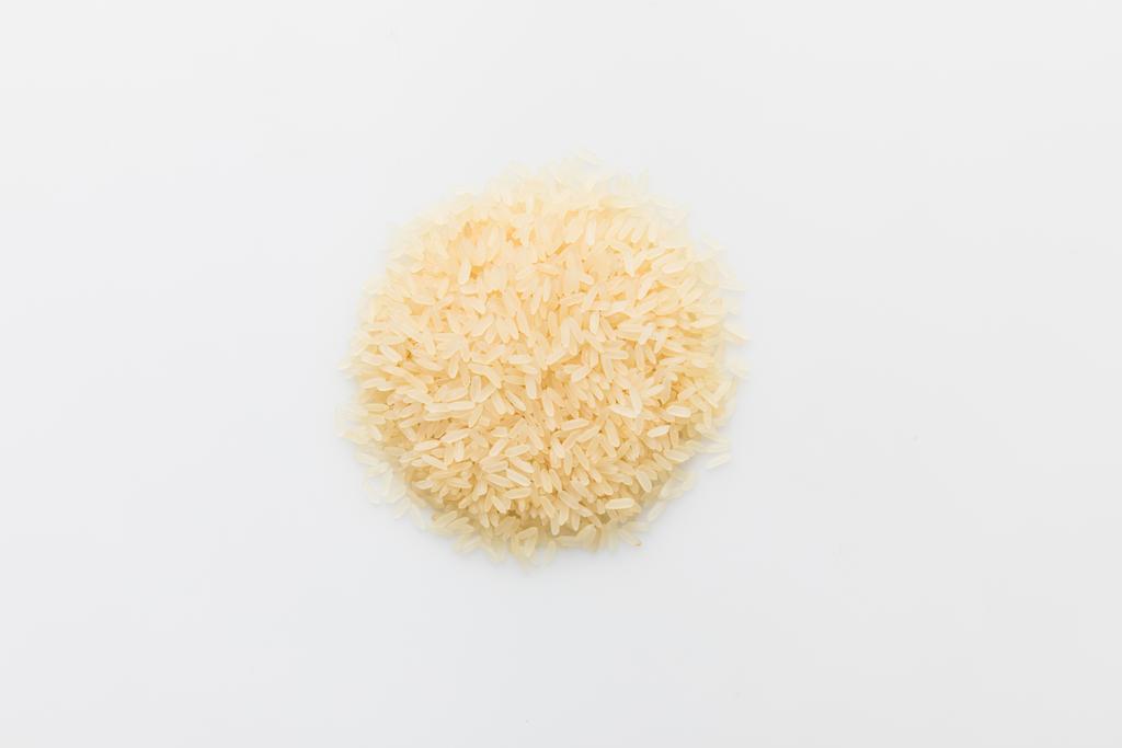 κάτοψη του σωρού ωμό ρύζι που απομονώνονται σε λευκό - Φωτογραφία, εικόνα