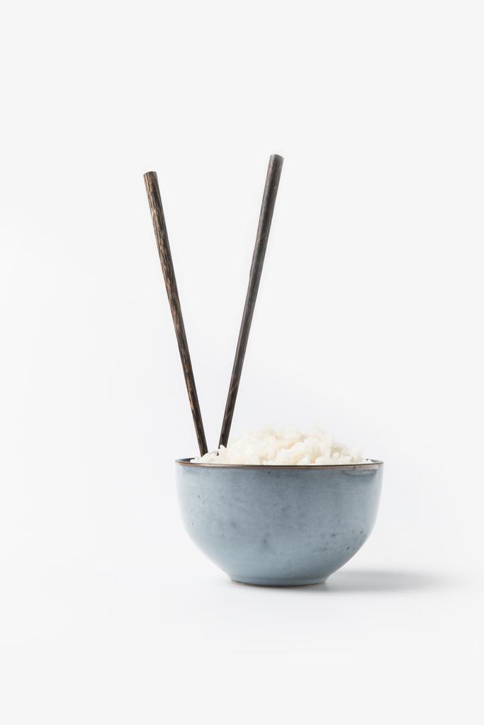 tazón de arroz recién cocido con palillos en la superficie blanca
 - Foto, Imagen