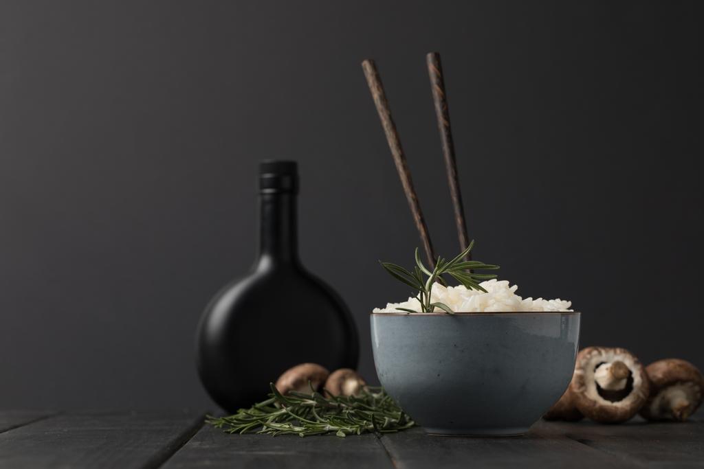 tigela de arroz com cogumelos e garrafa de molho de soja mesa preta
 - Foto, Imagem
