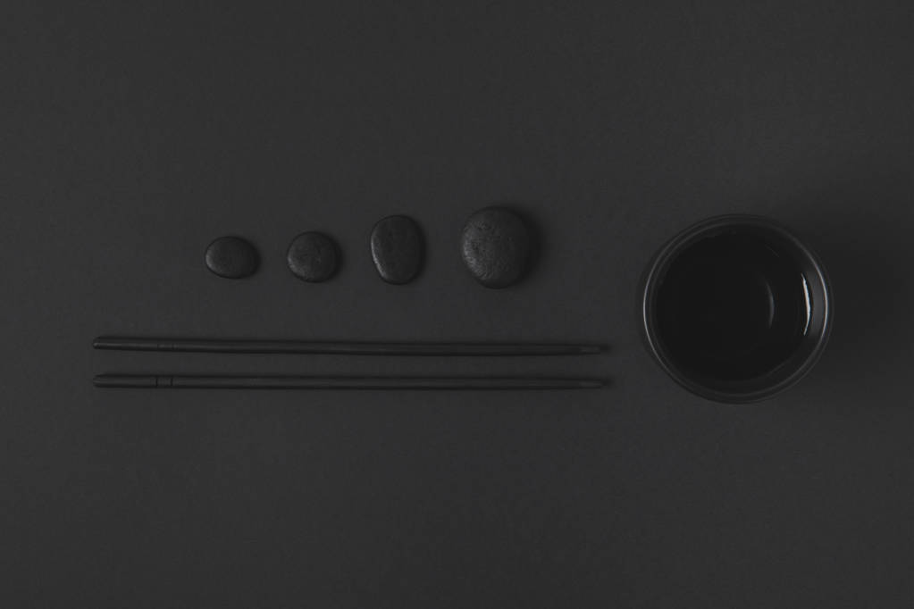 vue du dessus de baguette avec tasse de thé chinoise et cailloux sur noir
 - Photo, image