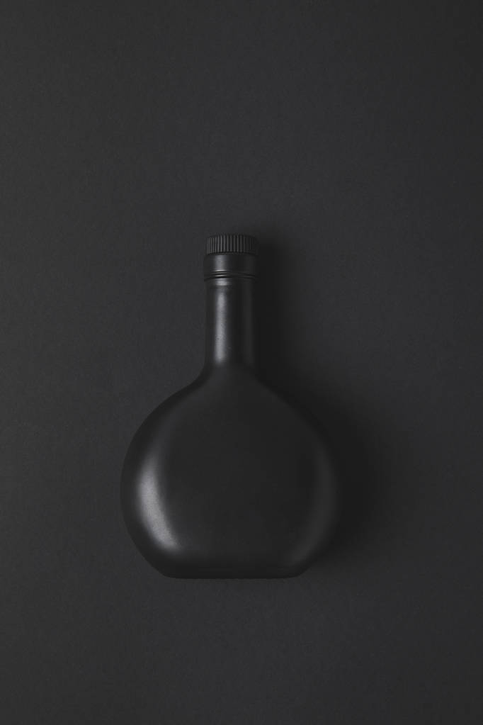 вид зверху порожня пляшка на чорній поверхні
 - Фото, зображення