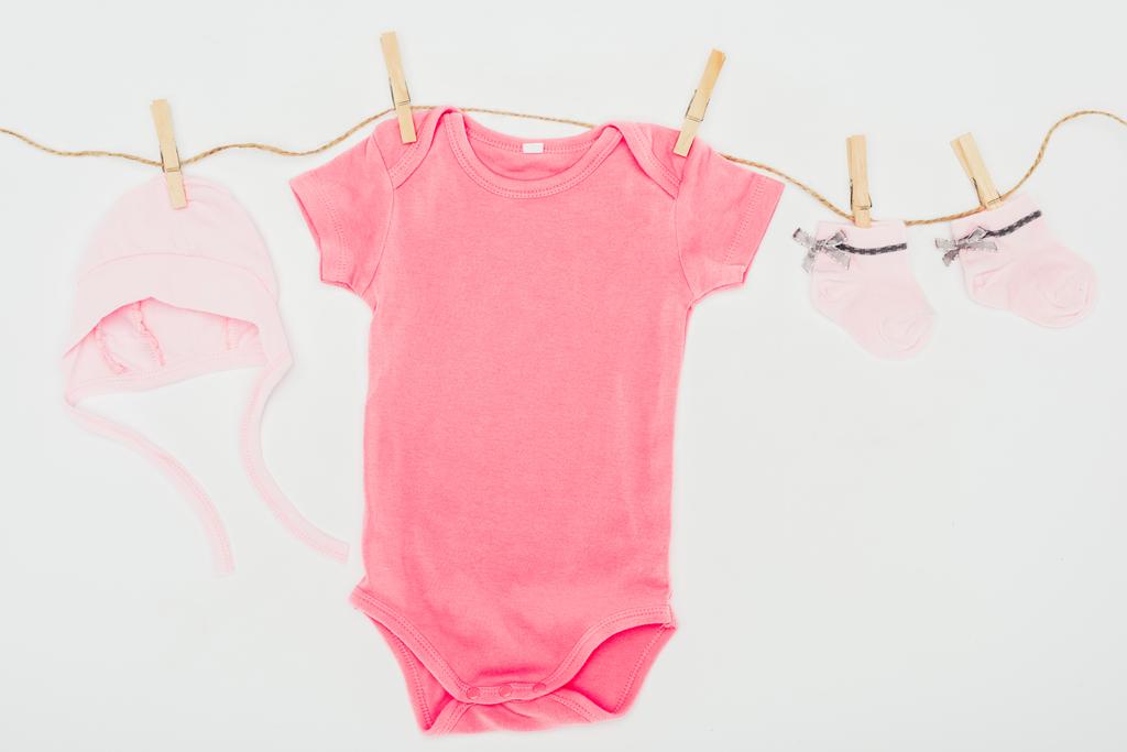 Draufsicht auf Babykleidung, die auf einem Seil trocknet, isoliert auf weiß - Foto, Bild